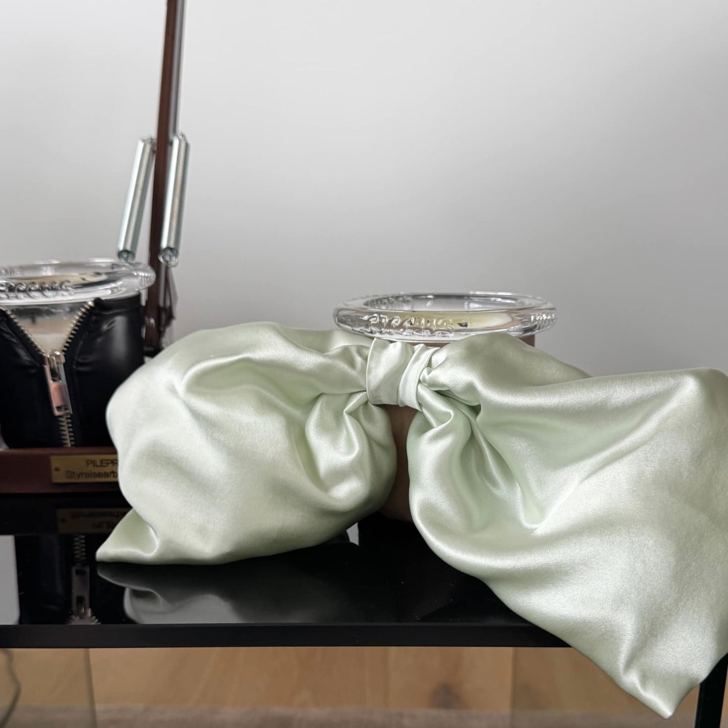 Founder Lee Lenox's glass side table featuring Bow Baby mint and khaki candle