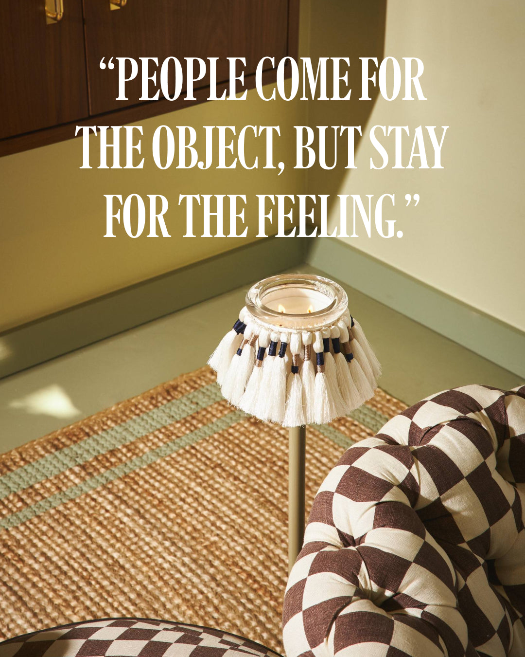 A styled interior scene fuzzed by circus candles on a metal stand beside a patterned armchair, with large overlaid text reading, “PEOPLE COME FOR THE OBJECT, BUT STAY FOR THE FEELING.”.