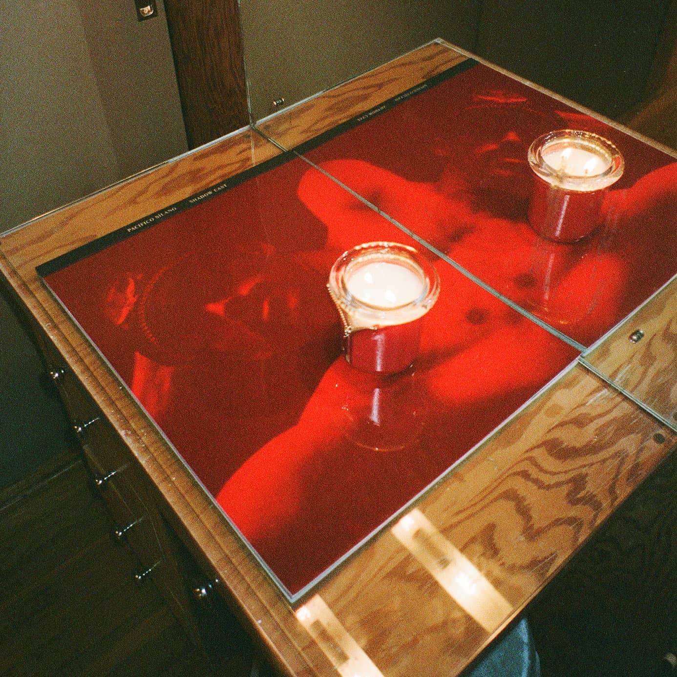 Interior Designer Benjamin Stelly's Austin studio with circus candle bound in red vinyl wrap styled on wood desk with sexy man