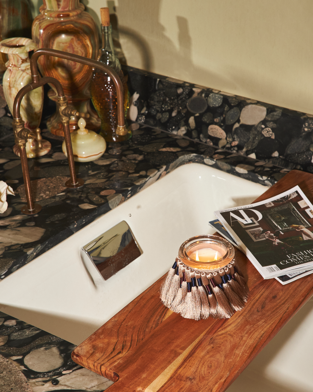 fuzzed in wheat with airy, warm and soft scent on wood shelf over a marble shower at interior designer jordan long's home