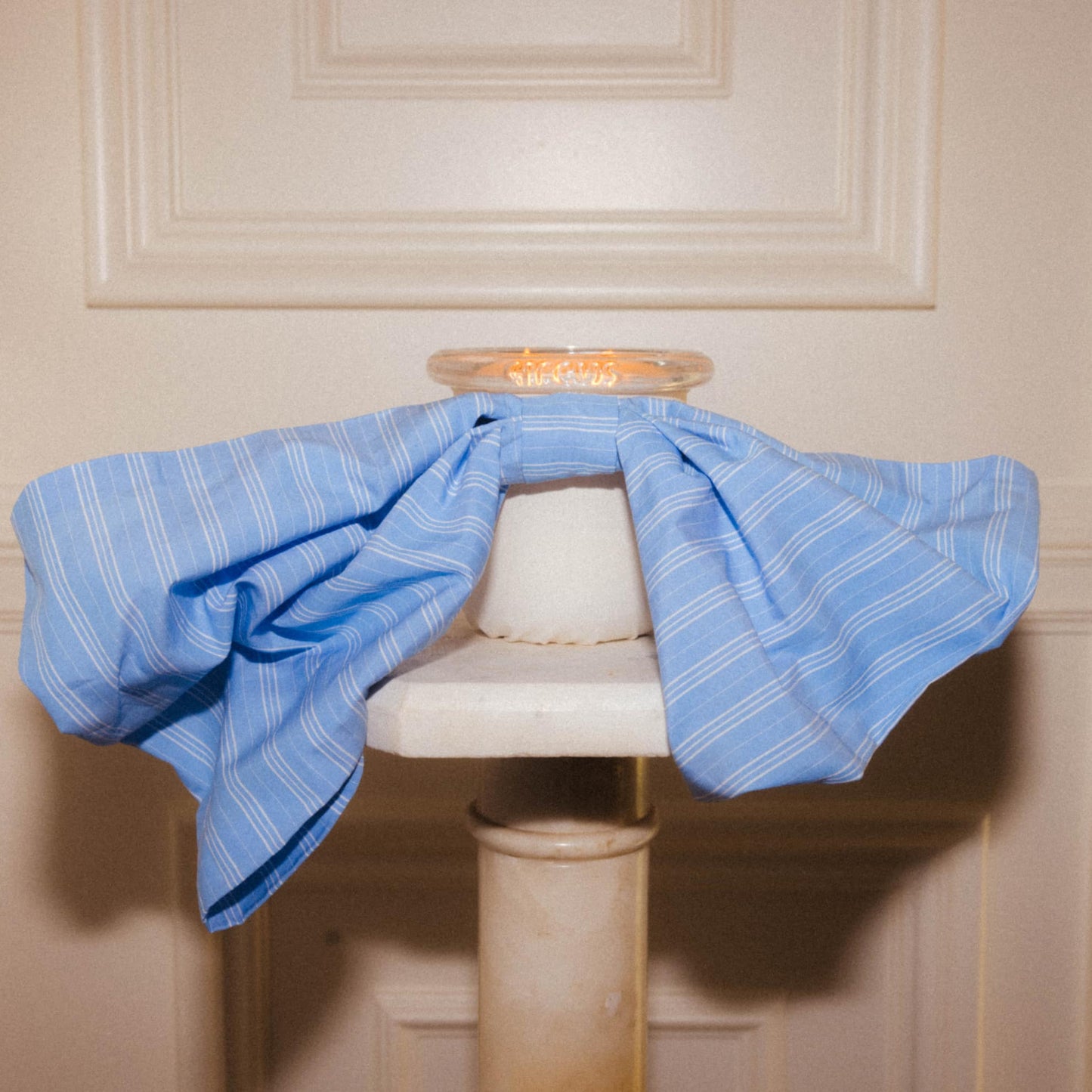 Art Director Colson Horton's home pedestal styled with Bow Baby candle in french and cream 