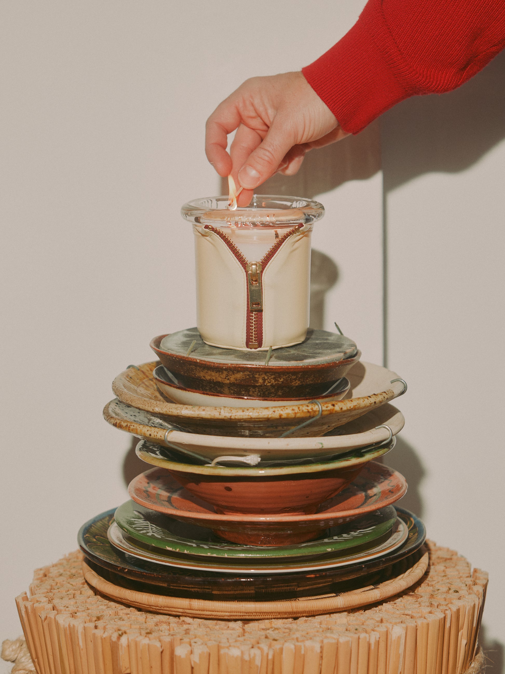 Decorator Conor Burke's NYC studio with Bound onyx and butter candle styled on stack of plates with match 