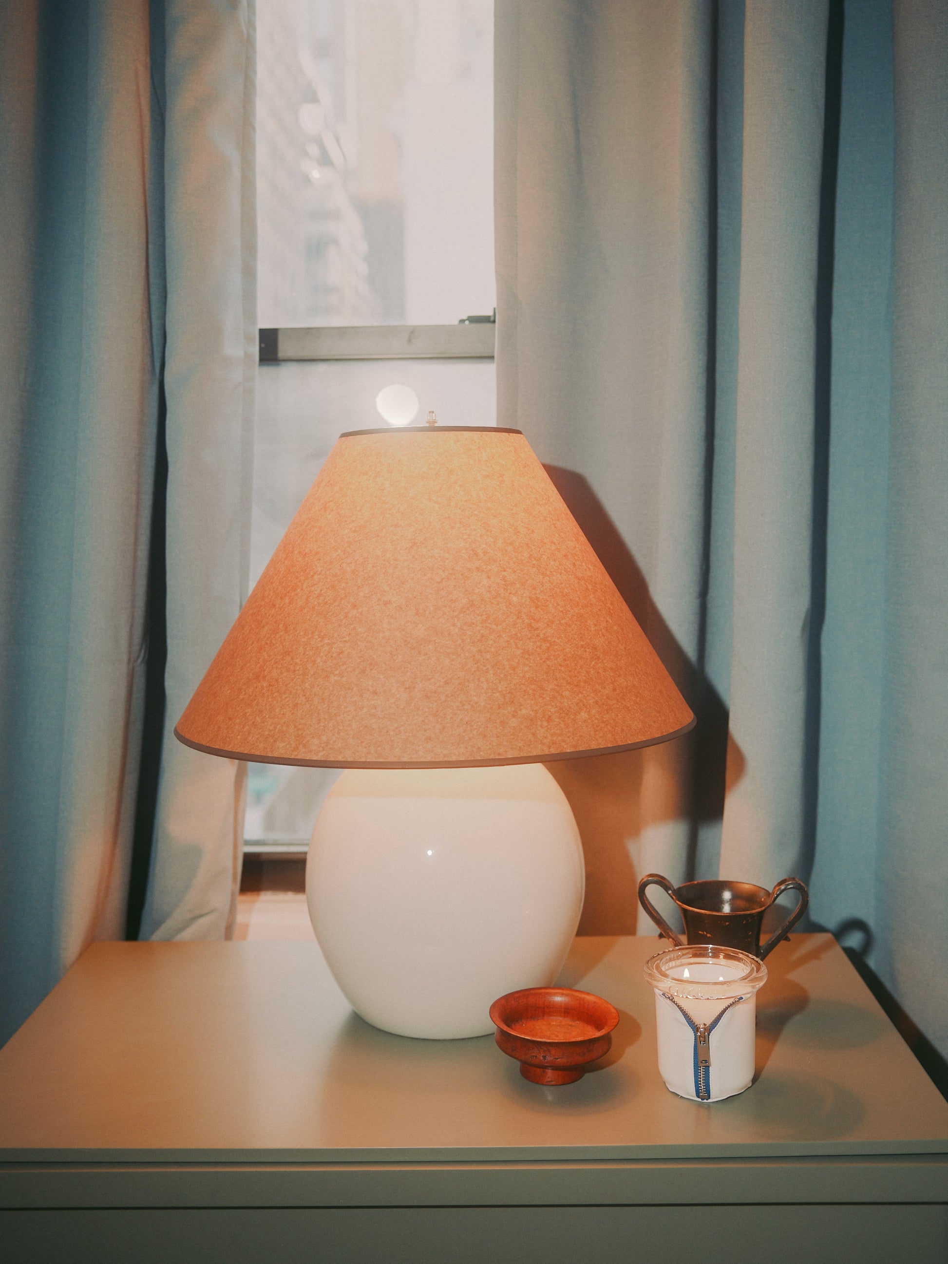 Decorator Conor Burke's NYC studio with Bound navy and white candle styled on chest of drawers with cream lamp
