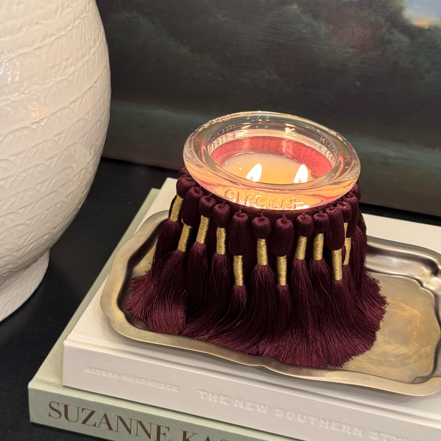 circus candle holder with burgundy tassels on a book