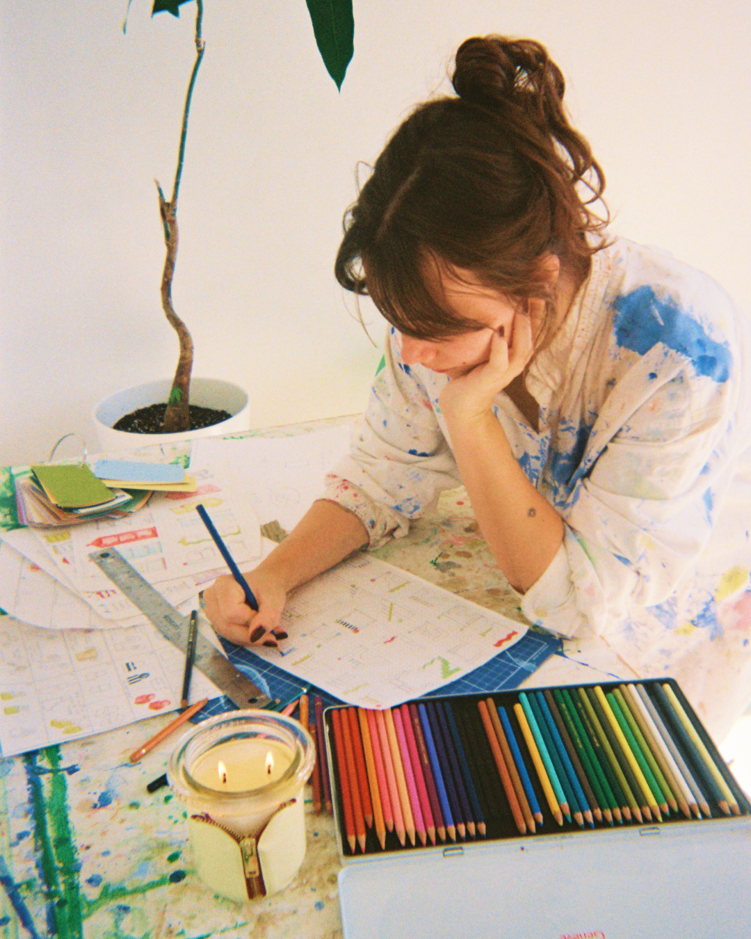 sophie colle at work sketching furniture for circus brand with a bound candle in butter and onyx lit