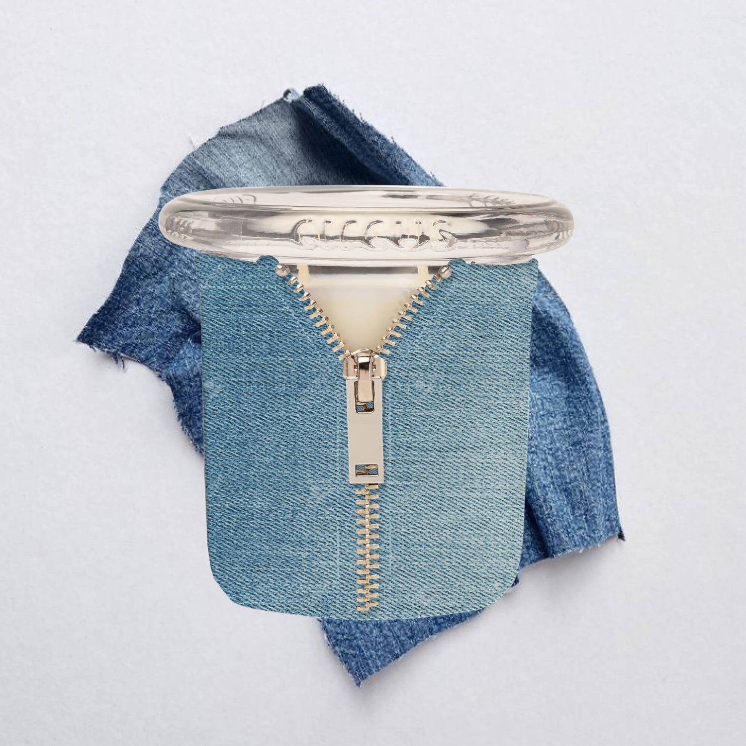 bound circus candle with a silver zipper design on a denim fabric background